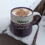 Tea Mug in the snow that says Making a Difference is what I do, inside the cup is a tea latte with cinnamon on top